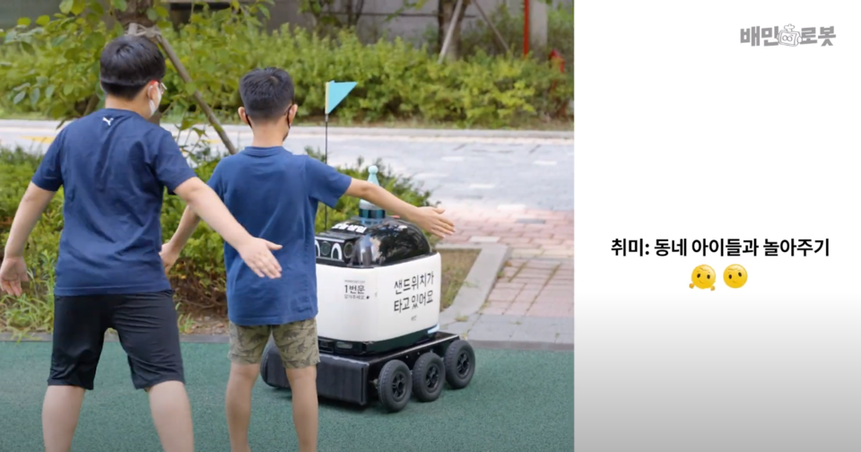 ‘우아한형제들’의 배달 로봇 ‘딜리(Dilly)’를 신기해하는 아이들 [사진 출처: ‘배민로봇딜리’ 공식 유튜브 채널]