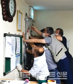 9월 3일 D사 측이 관리사무소 철문을 망치로 내리치자 S사 측 직원들이 이를 막고 있다.