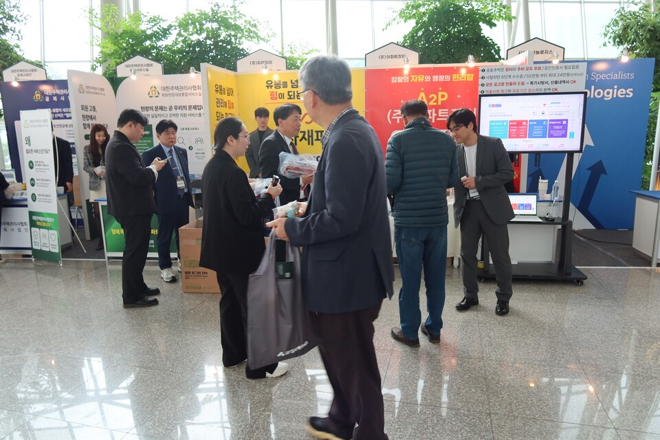 주택관리사들이 행사장 외부에 마련된 공동주택 관리 관련 업체들의 부스를 방문해 설명을 듣고 있다.