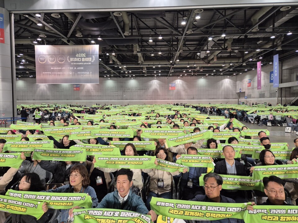 주택관리사 회원들이 배부된 스포츠 타올을 들고 환호하고 있다.